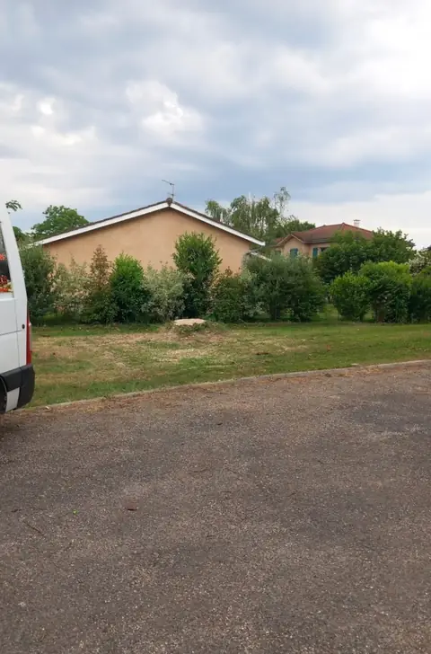 Après : Le terrain dégagé devant la maison, l'arbre abattu.